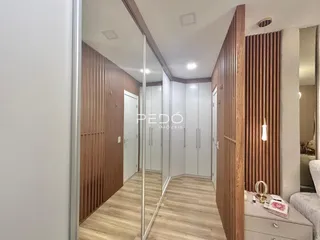 Hall de entrada com revestimento de madeira e piso claro.