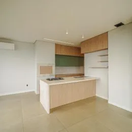 Cozinha com armários de madeira clara e bancada.