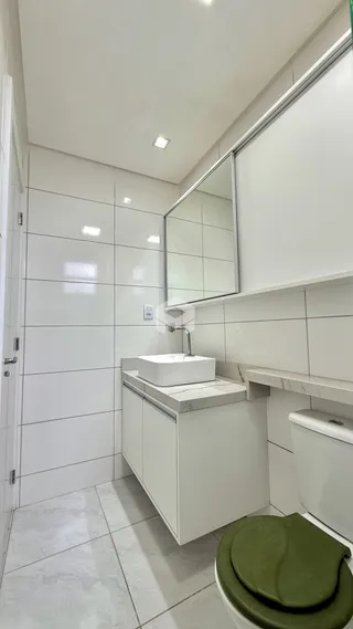 Foto de um banheiro com revestimento branco e bancada.