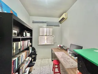 Quarto com estante e mesa de trabalho em um imóvel no Brasil.