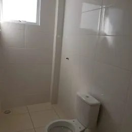Foto de um banheiro com revestimento cerâmico branco.