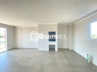Ambiente interno amplo com piso de porcelanato cinza e paredes brancas.