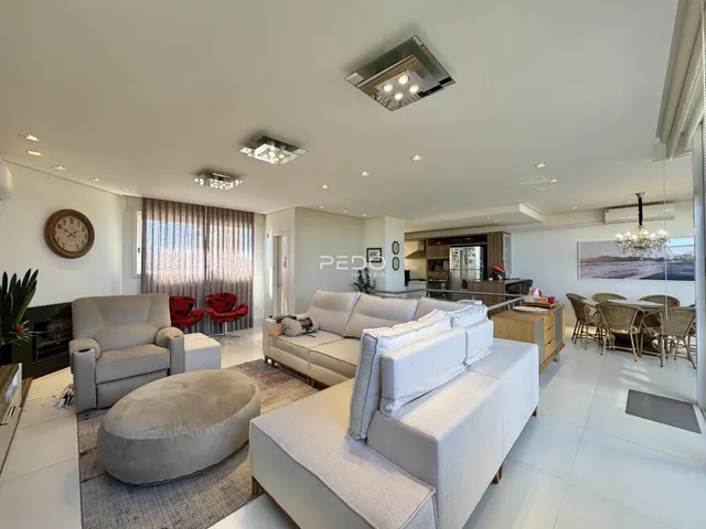 Sala de estar moderna com sofás brancos e piso claro.