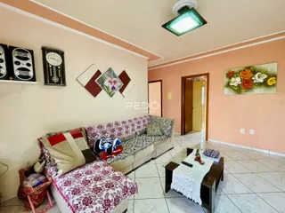 Sala de estar com sofá e decoração em tons de rosa e branco.