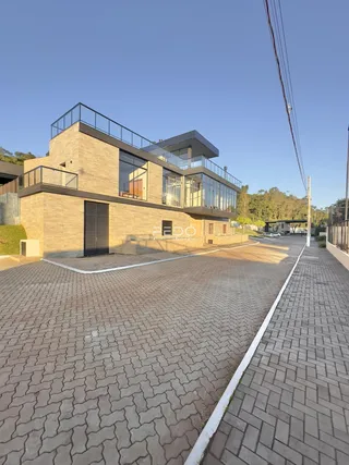 Fachada moderna de uma residência em Lajeado, Brasil, com área externa pavimentada.