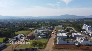 Vista aérea de uma área residencial com casas e campos no entorno de Lajeado, Brasil.