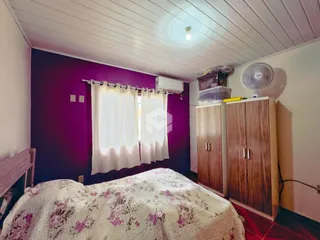 Quarto com paredes roxas e armários de madeira em Lajeado.