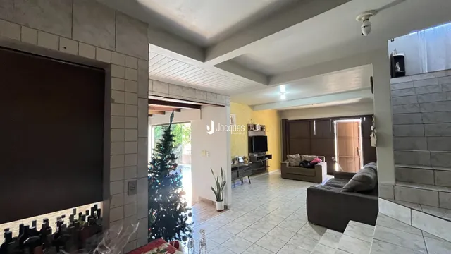 Sala de estar com decoração moderna e árvore de Natal visível na entrada