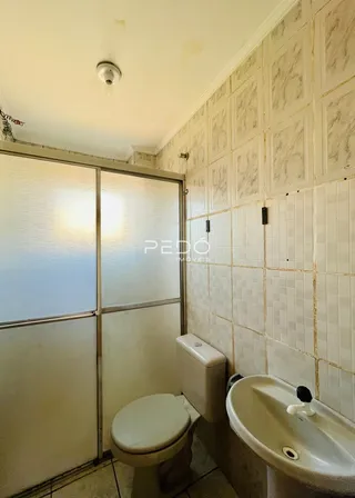 Foto de um banheiro com azulejos brancos e louças sanitárias.