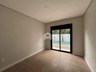 Ambiente interno com piso de madeira e porta de vidro.