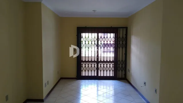 Corredor interno com piso de cerâmica e portas de ferro.