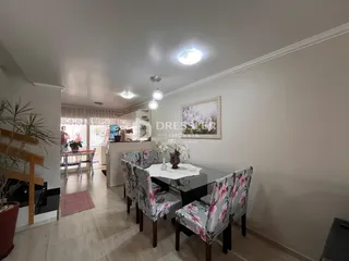 Uma sala de jantar com mesa e cadeiras é visível no interior da propriedade.