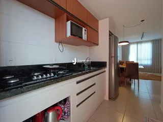 Cozinha moderna com armários de madeira e bancada escura.