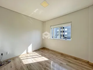 Ambiente interno de uma sala com piso de madeira clara.