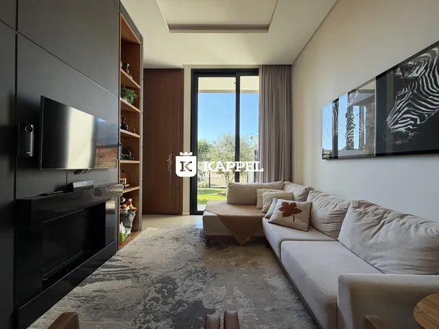 Sala de estar moderna com sofá e televisão.