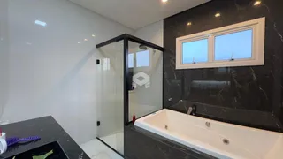 Banheiro moderno com banheira e box de vidro em um ambiente de alto padrão.