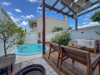 Vista de uma piscina e deck de madeira em uma propriedade no Brasil.