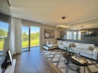 Sala de estar moderna com grandes janelas e vista para a paisagem verde.