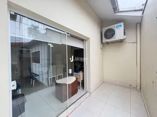 Vista de uma sala de transição com porta de vidro que dá acesso a uma área externa.