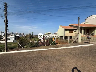 Fachada de uma casa em Lajeado, Brasil, com vegetação e poste de luz na frente.