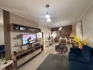 Sala de estar com sofá azul, painel de TV e decoração moderna.
