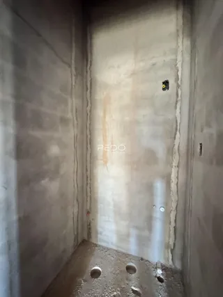 Parede interna de um imóvel com acabamento bruto.