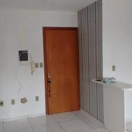 Foto de um corredor interno com porta de madeira e piso de cerâmica.