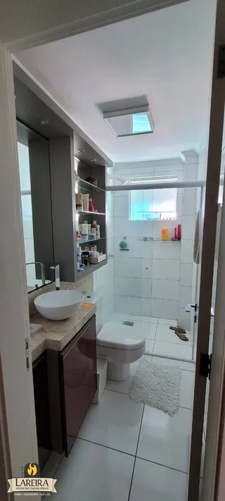 Foto de um banheiro interno com piso de cerâmica e louças sanitárias brancas.