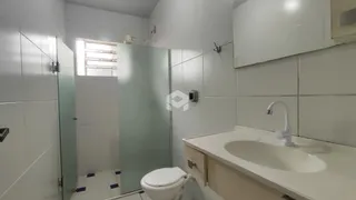 Foto de um banheiro com revestimento cerâmico e pia branca.