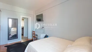 Quarto com cama e espelho em um apartamento.