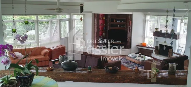 Sala de estar com piso de madeira e lareira em imóvel no Brasil.