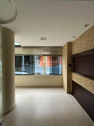 Interior da sala com piso claro e parede texturizada.