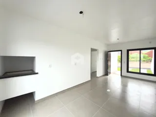 Espaço interno de uma sala com paredes brancas e piso de cerâmica.