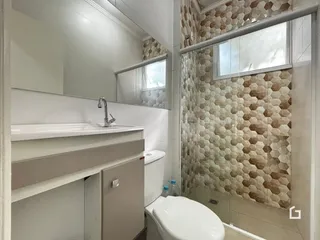 Interior de um banheiro com revestimento de azulejos hexagonais nas paredes.