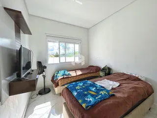 Quarto com duas camas e janela em um apartamento.