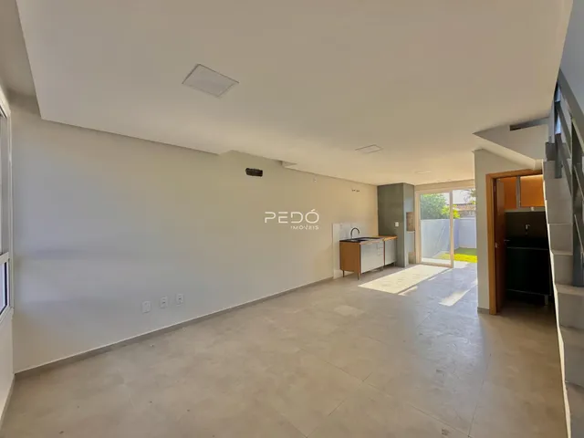 Sala de estar ampla com piso de cerâmica clara.