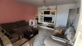 Sala de estar com sofá e piso cerâmico em uma residência.