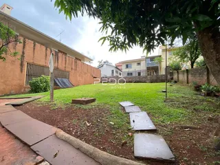 Vista externa de uma residência com jardim e calçada.
