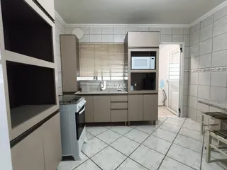 Esta é uma foto de uma cozinha com armários e piso claro.