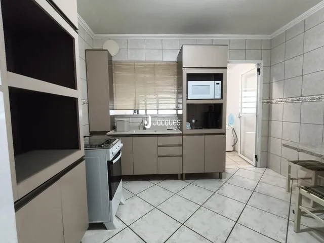 Esta é uma foto de uma cozinha com armários e piso claro.