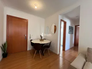 Interior de uma sala de jantar com piso de madeira e porta de madeira.