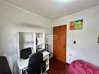 Quarto com armário e mesa de trabalho em sala.