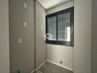 Vista de um corredor interno com parede lisa e janela.