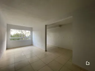 Interior de uma sala com piso de cerâmica clara e janela.