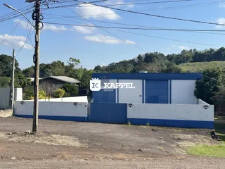 Vista externa de um prédio comercial azul e branco em Lajeado, Brasil.