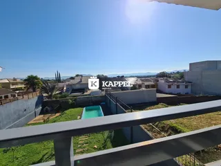 Vista panorâmica de uma área residencial com piscina e paisagem ao fundo.