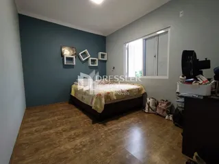 Quarto com cama e piso de madeira em um imóvel no Brasil.
