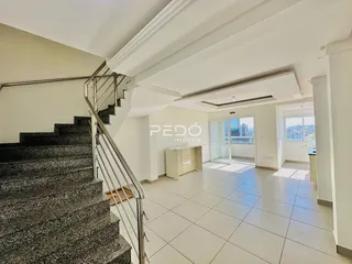 Hall de entrada com escadaria e piso de cerâmica em imóvel no Brasil.