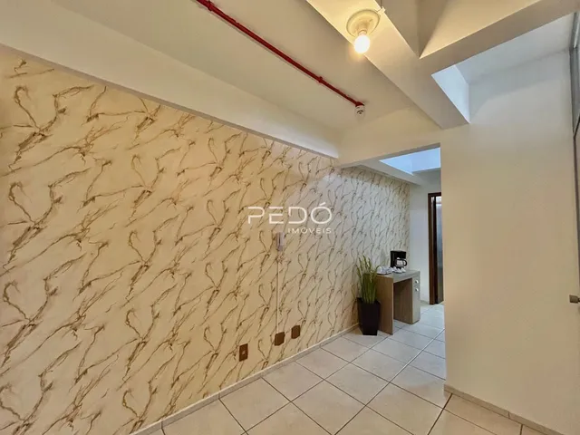 Parede interna com revestimento em tons terrosos e piso de cerâmica clara.
