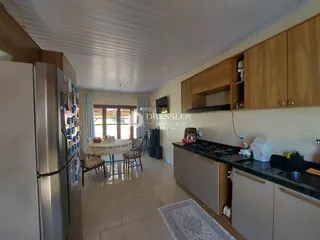 Vista interna de uma sala de estar com cozinha em um imóvel no Brasil.